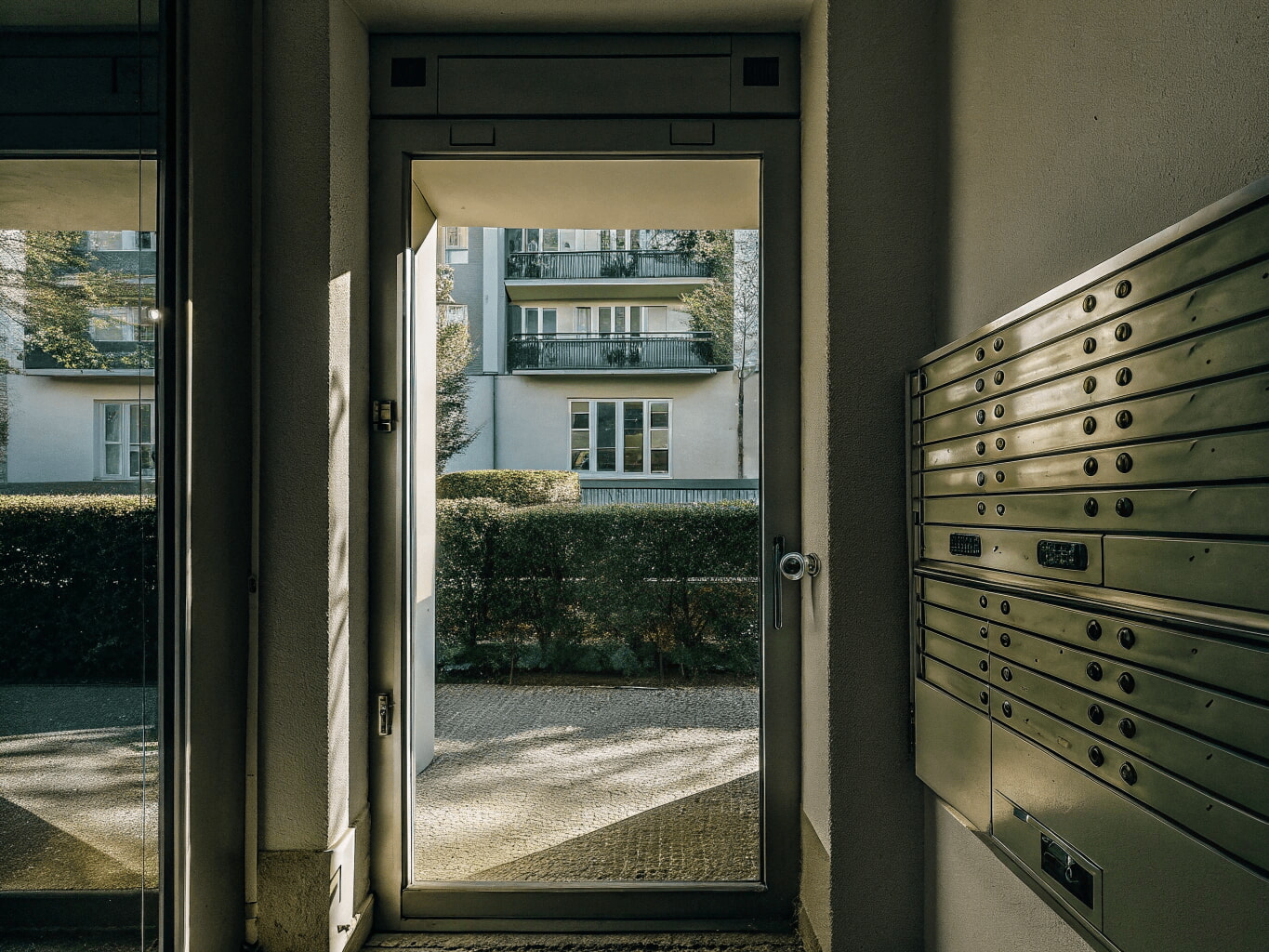 Entrance to a modern Portuguese office building with a mailbox
